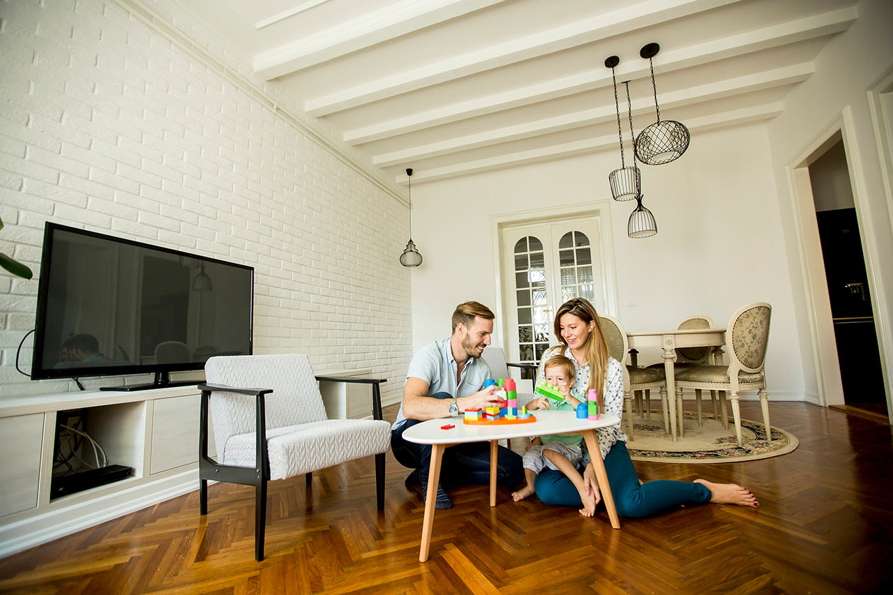 Šťastná rodina v modernej obývacej izbe s tradičným jedálenským setom