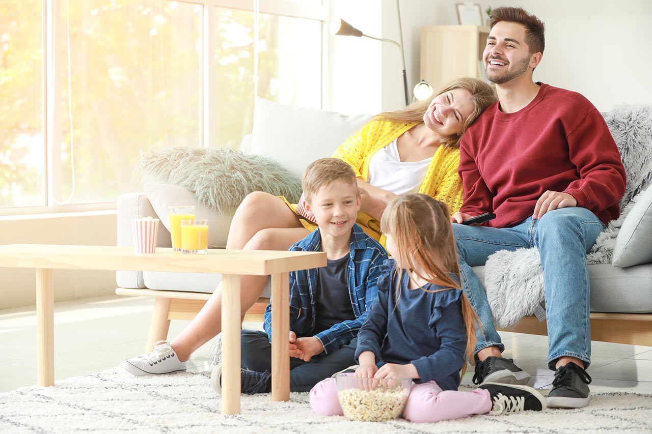 Šťastná rodina vo svetlej moderne a jednoducho zariadenej obývačke